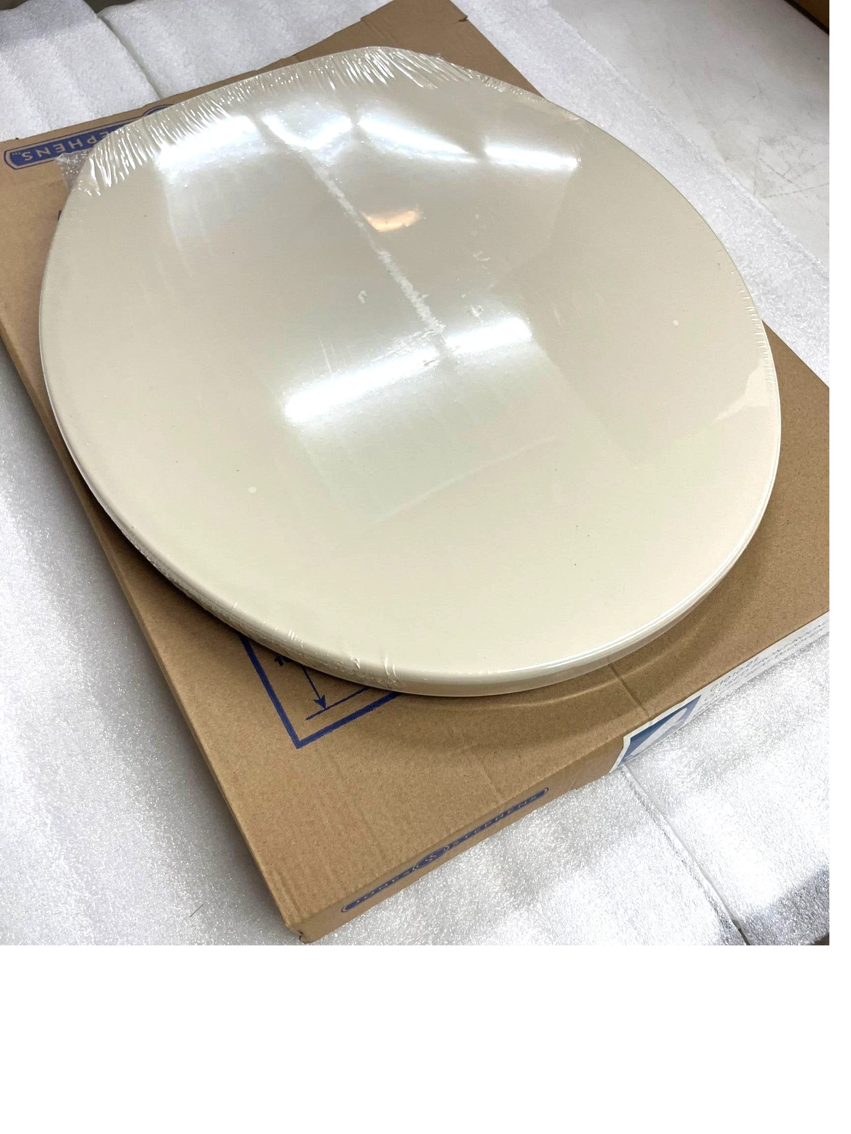 North Country Supply Jones Stephens round plastic toilet seat in bone finish with closed-front cover in packaging.
